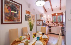 a dining room with a table and a kitchen at Cozy Home In Mudri Dolac With Kitchen in Basina