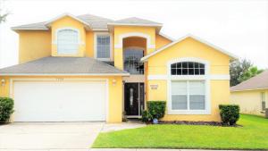 a yellow house with a white garage at 6 bedrooms pool home 10 min from Disney in Orlando