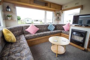 - un salon avec un canapé, une télévision et une table dans l'établissement Great 4 Berth Caravan At Withernsea Sands Ref 79003hg, 