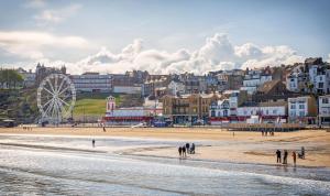 a group of people walking on the beach in front of a town at Great 4 Berth Caravan At Withernsea Sands Ref 79003hg 