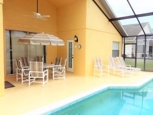 een patio met een tafel en stoelen en een zwembad bij 6 bedrooms pool home 10 min from Disney in Orlando