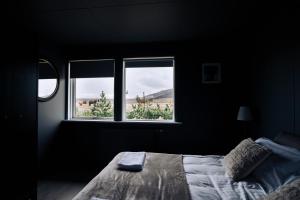 a bedroom with a bed and two windows at Golden Circle Luxury Cottages in Selfoss