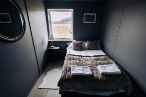 a small bedroom with a bed and a window at Golden Circle Luxury Cottages in Selfoss