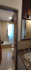 里奧誇爾托的住宿－DEPARTAMENTO DEL PARQUE，浴室设有3个卫生间、水槽和镜子