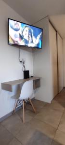 - un bureau avec une télévision murale et une chaise dans l'établissement DEPARTAMENTO DEL PARQUE, à Río Cuarto
