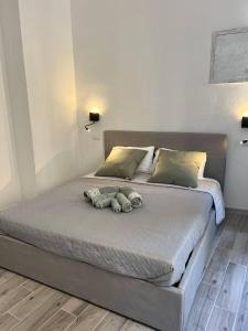 un lit avec deux animaux farcis au-dessus dans l'établissement Rooms Via XX Settembre, à Capoterra