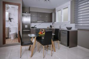una cucina con tavolo, sedie e lavandino di Unique1 - Private Lux city apartment a Heraklion