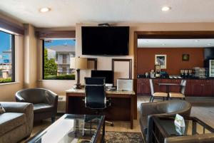 a living room with a desk and a tv at SureStay Plus Hotel by Best Western Jackson in Jackson