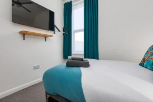 a bedroom with a bed with a flat screen tv on the wall at Charles Alexander Short Stay - TheWestern Blackpool in Blackpool