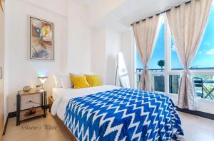 a bedroom with a bed and a large window at Mactan Newtown - 1BR Stunning Ocean View and City View in Mactan