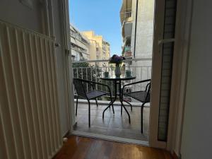 an open door to a balcony with a table and chairs at Traveller's Choice Attiki in Athens