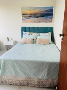 a bedroom with a bed with a blue headboard at Apto Vista Mar - Jacumã in Conde