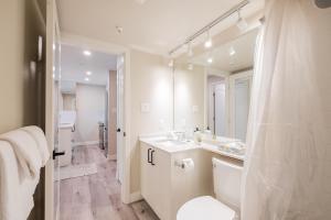 a bathroom with a sink and a toilet and a mirror at The Aspens by Outpost Whistler in Whistler