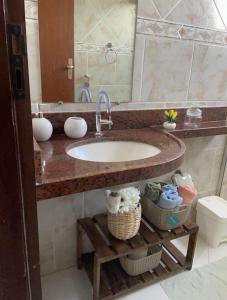 a bathroom counter with a sink and a mirror at Apto Vista Mar - Jacumã in Conde