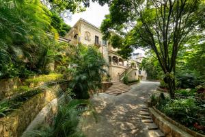 an old house with a staircase in a garden at Hotel Stein Colonial in Cali