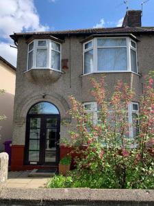 uma casa com uma porta, uma janela e um arbusto em 3 BEDROOM HOUSE IN A GREAT LOCATION em Childwall