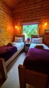 a bedroom with two beds in a wooden cabin at Secluded 3Bed Lodge with hot tub North Yorkshire in Skipton