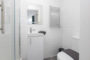 a white bathroom with a toilet and a mirror at Charles Alexander Short Stay - TheWestern Blackpool in Blackpool