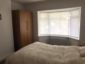 um quarto com uma cama e uma janela em 3 BEDROOM HOUSE IN A GREAT LOCATION em Childwall