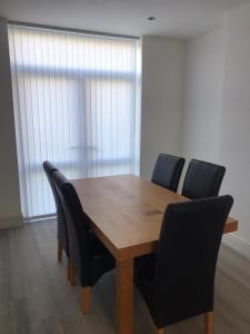 a wooden table with black chairs in a room at 3 BEDROOM HOUSE IN A GREAT LOCATION in Childwall