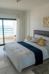 a bedroom with a large bed with a view of the ocean at Ocean Blue II in Quarteira