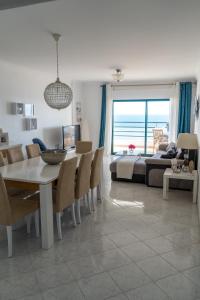 a dining room and living room with a table and chairs at Ocean Blue II in Quarteira