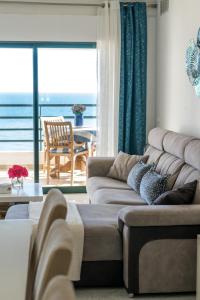 a living room with a couch and a view of the ocean at Ocean Blue II in Quarteira