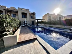 ein Schwimmbad in der Mitte eines Hauses in der Unterkunft Luxurious Villa with Infinity Private Pool & Jacuzzi over Sabina Island's Lagoon in Hurghada
