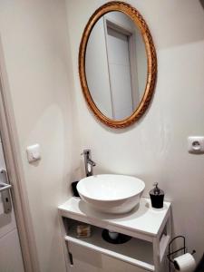 a bathroom with a sink and a mirror on the wall at appartement Rez-de-chaussée avec extérieur, a 150m du centre, 4min de la plage. in Mers-les-Bains