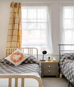 a bedroom with two beds and a window at Homestay near Tottenham Hotspur Stadium in London