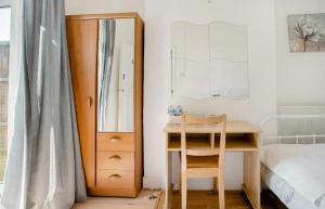 a bedroom with a desk and a mirror and a bed at Homestay near Tottenham Hotspur Stadium in London