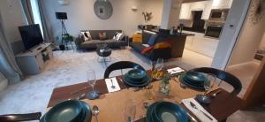 uma sala de estar com mesa e cadeiras e uma sala de estar em Rare luxury Harbourview apartment sleeps 6 em Torquay