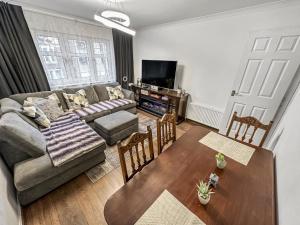 ein Wohnzimmer mit einem Sofa und einem Tisch in der Unterkunft Comfortable 2 Bedroom Flat In The City Centre in Edinburgh