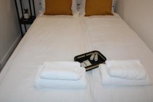 - un lit blanc avec des serviettes et une valise dans l'établissement Zentrales schickes Apartment, à Heilbronn