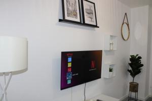 Elle comprend une télévision à écran plat suspendue sur un mur blanc. dans l'établissement Zentrales schickes Apartment, à Heilbronn