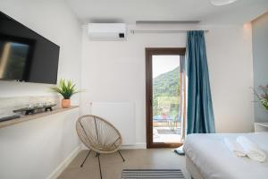 1 dormitorio con 1 cama, 1 silla y 1 ventana en Villa Scorpios en Kynopiástai