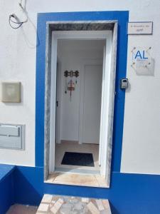 uma porta azul e branca para um quarto em a casinha da avó na Zambujeira do Mar