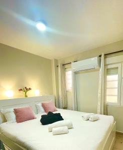 een slaapkamer met een groot wit bed met roze kussens bij MADRID CENTRO in Madrid