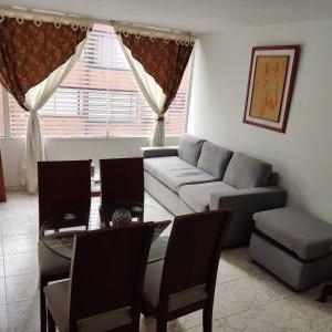 ein Wohnzimmer mit einem Sofa und einem Tisch in der Unterkunft APARTAMENTO COMODO NORMANDIA in Bogotá