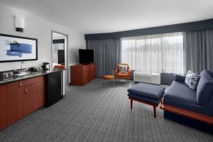 a hotel room with a couch and a tv at Courtyard by Marriott San Diego Rancho Bernardo in Rancho Bernardo