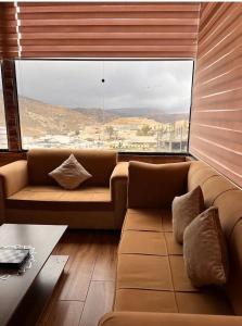 a living room with a couch and a large window at Petra Cabin Inn Hostel&Resturant in Wadi Musa
