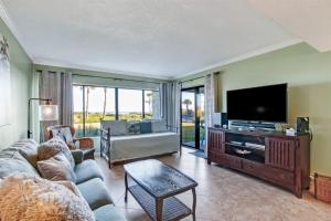 a living room with a couch and a tv at Sol Y Mar A103 Surf Racquet Club in Fernandina Beach