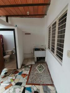 a bathroom with a toilet and a mosaic floor at Casa de relajación low cost in La Dorada