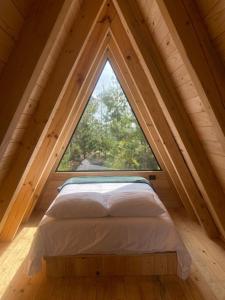 a bed in a room with a large window at Cabañas Chalets Piedra Alta Zacatlan in Camotepec