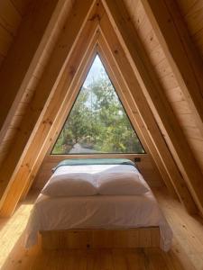 un letto in una camera con una grande finestra di Cabañas Chalets Piedra Alta Zacatlan a Camotepec