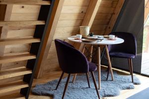 a table and two chairs in a room with stairs at Cabañas Chalets Piedra Alta Zacatlan in Camotepec
