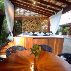 a wooden table with a bath tub in a backyard at Pousada do Bispo in Cabo Frio