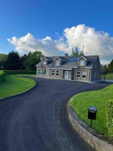 una casa grande con una entrada delante de ella en Luxury Home In Mourne Mountains, en Mayobridge