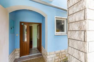 a blue house with a door and a window at Apartment Brsec 7796b in Martina