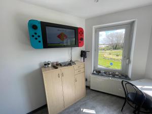 um quarto com uma televisão de ecrã plano na parede em Studio petit plus gaming ! em Calais